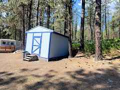 view of storage shed and home view of storage shed and home